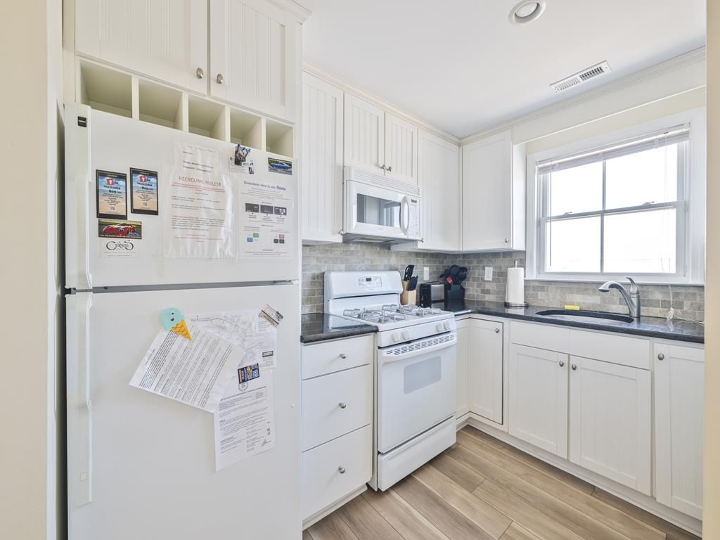 image Step into a bright kitchen featuring white cabinetry and modern appliances, perfect for family meals.