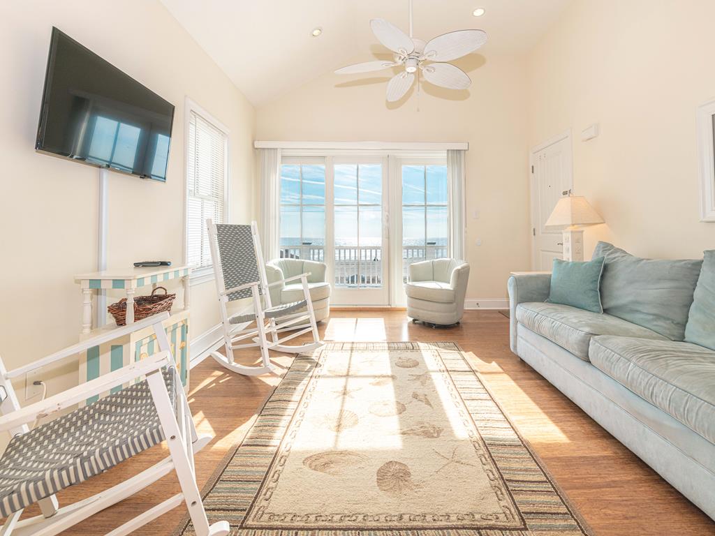 image Relax in the bright living room featuring plush sofas, soft tones, and stunning ocean views through wide windows.