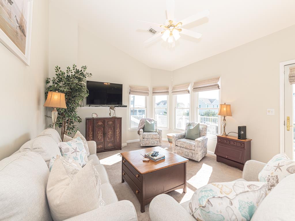 image Bright and airy living room with large windows, a smart TV, and comfortable seating, perfect for relaxing with loved ones.