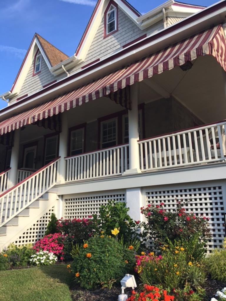 image Charming front porch with lush landscaping, perfect for relaxing after a day at the beach.