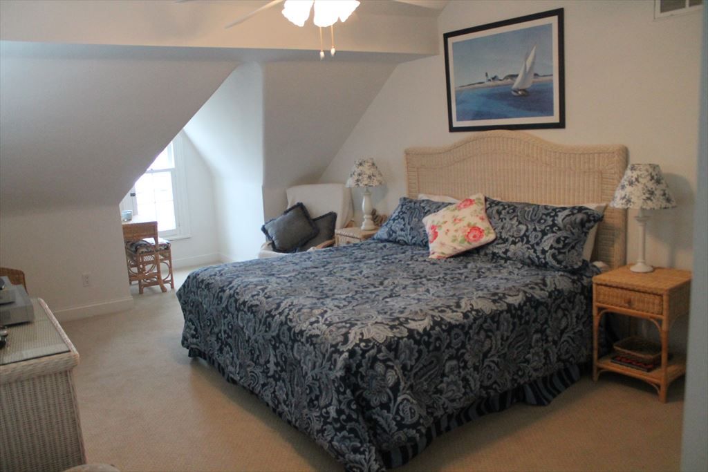 image Spacious bedroom with a king-size bed, vaulted ceilings, and cozy decor for a restful night’s sleep.
