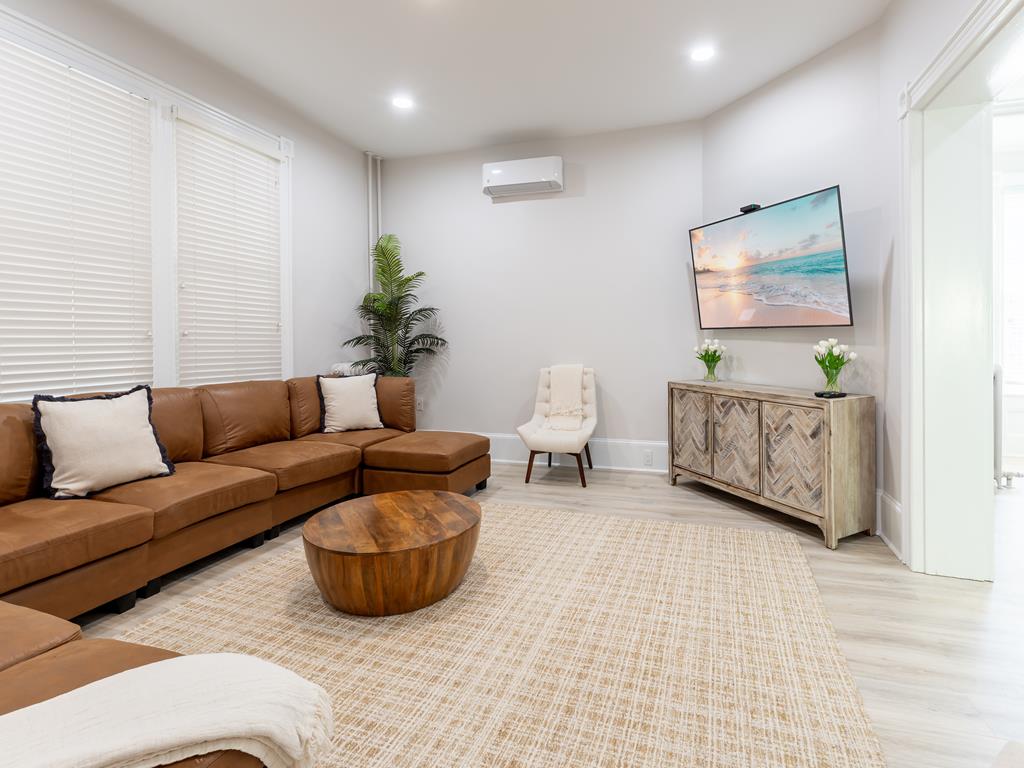 image Spacious and stylish living room with a large sectional sofa, perfect for relaxing and spending quality time with your group.