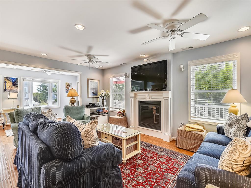 image Sunlit living space with ample seating, perfect for socializing or enjoying a quiet moment by the fireplace.