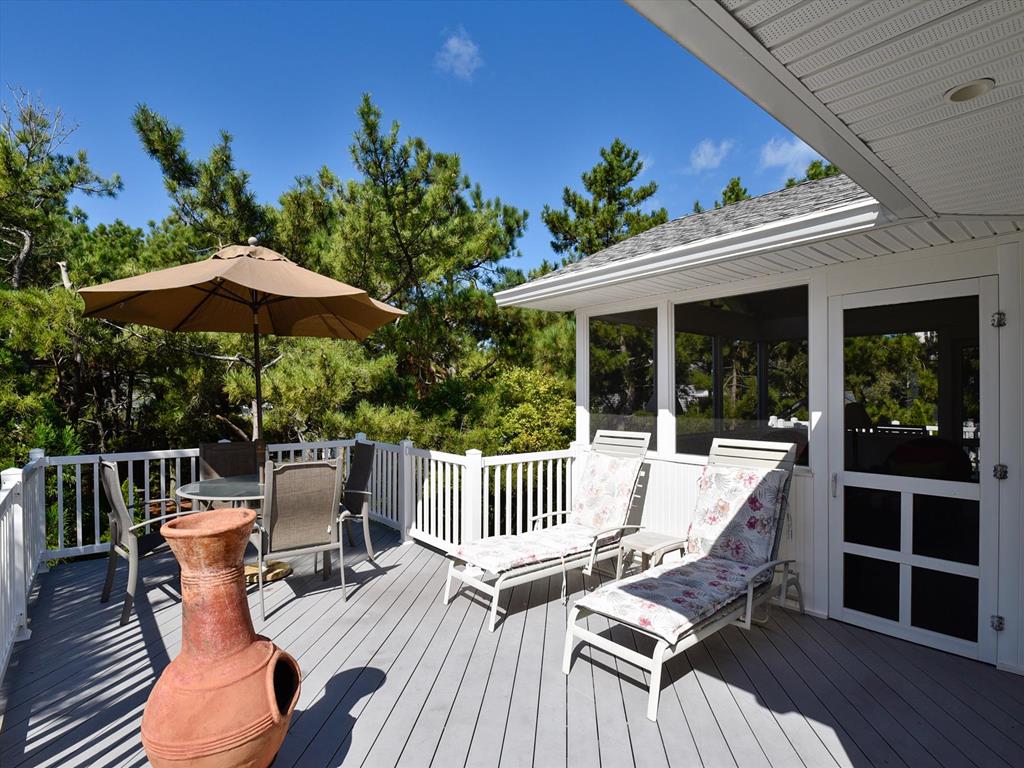 image Rooftop deck with inviting outdoor seating and a shaded area, perfect for enjoying sunny days and starry nights.