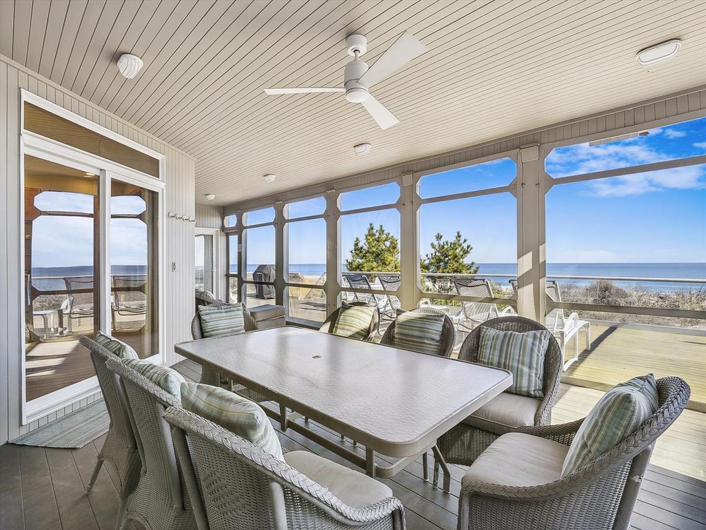 image Screened outdoor dining area with ocean views, perfect for al fresco meals while enjoying the sea breeze.