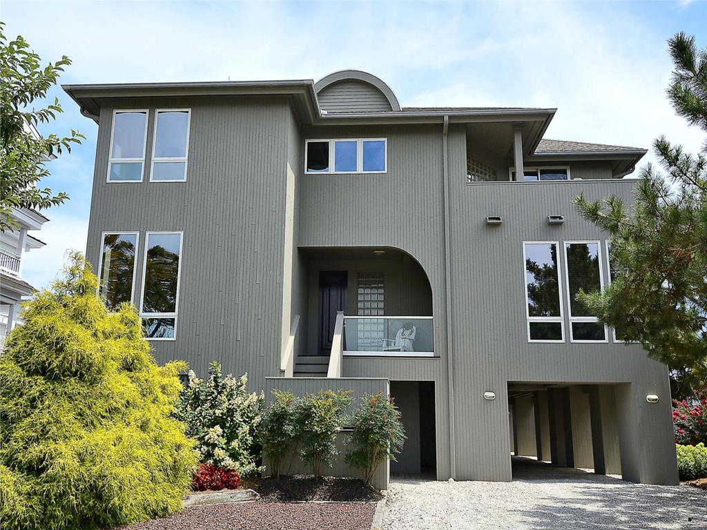 image Modern architectural design with lush landscaping, offering a grand entrance to this luxurious oceanside retreat.