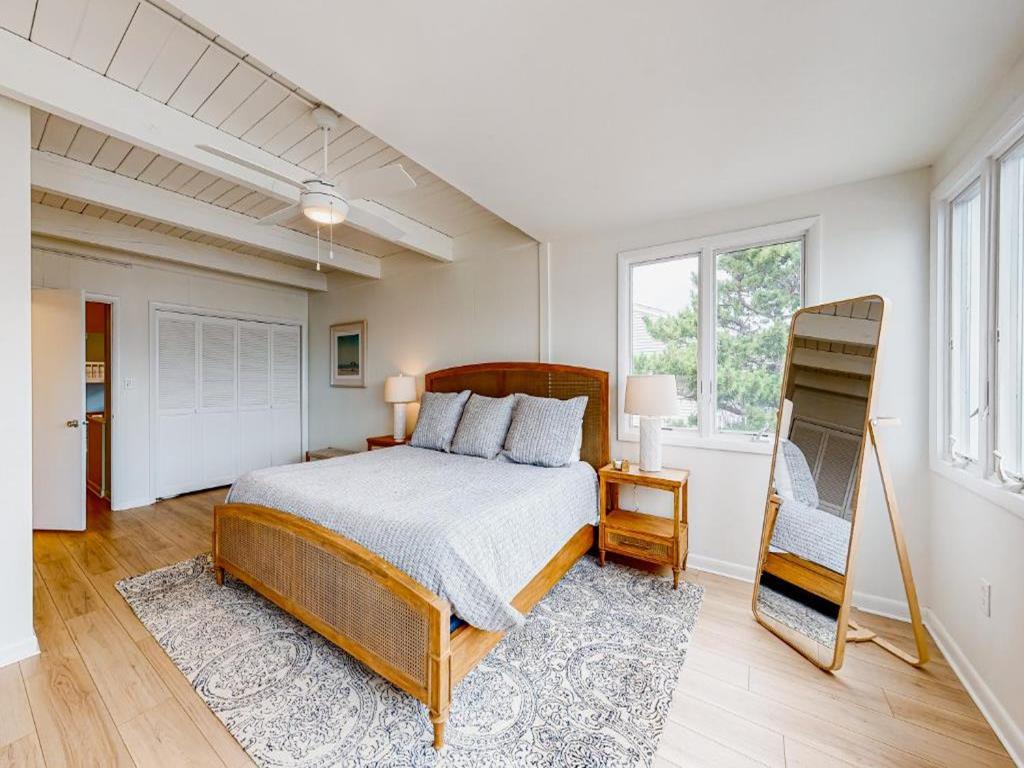 image Stylish primary bedroom featuring a comfortable bed, ample space, and a relaxing atmosphere to unwind after a beach day.