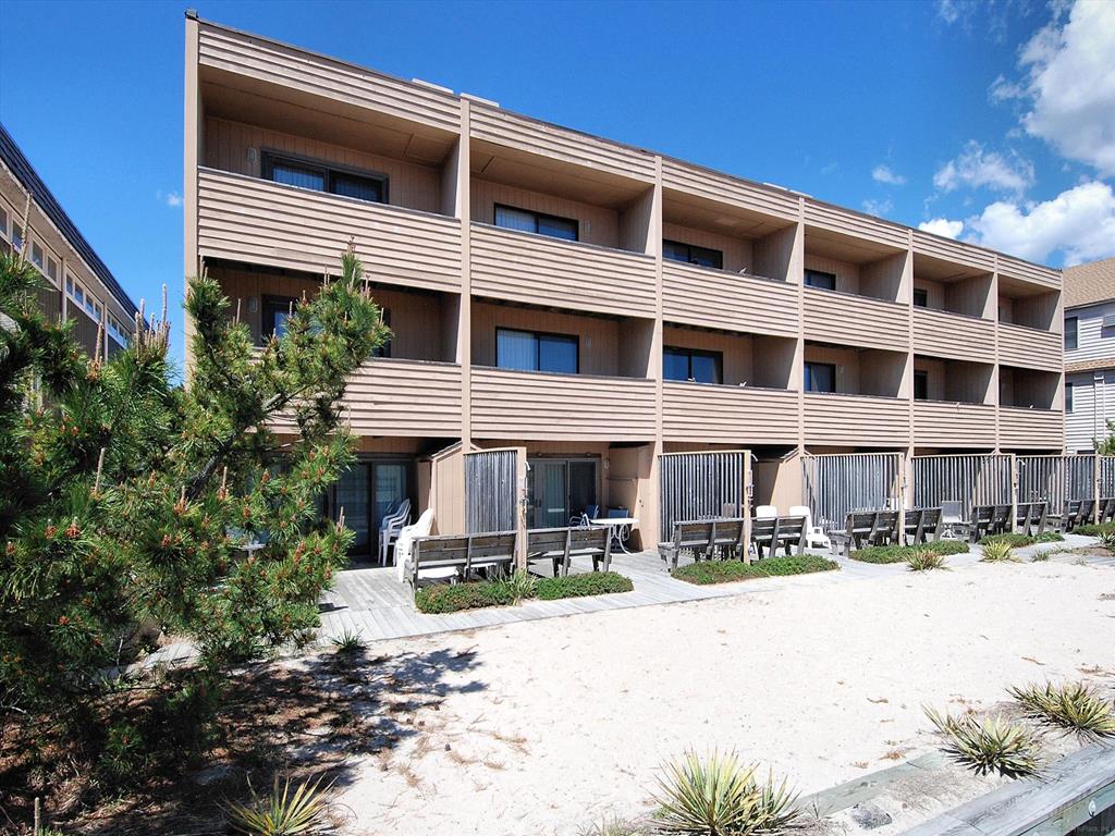 image Back view of the property, showcasing balconies and the proximity to the sandy dunes and beach access.