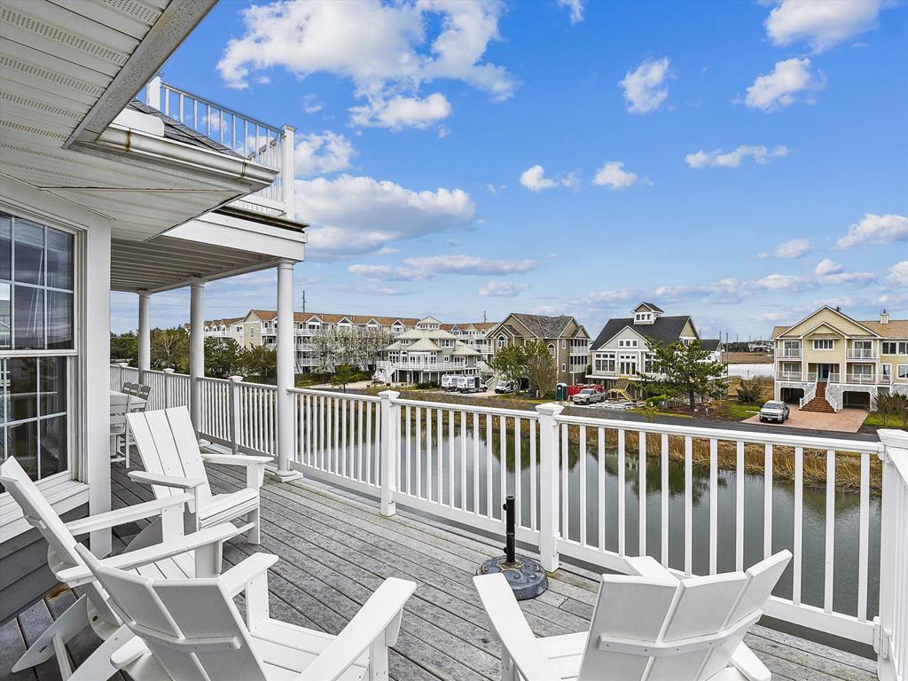 image Experience serene waterfront living on this expansive deck, perfect for soaking up the sun, with scenic canal views and luxury beach house features.