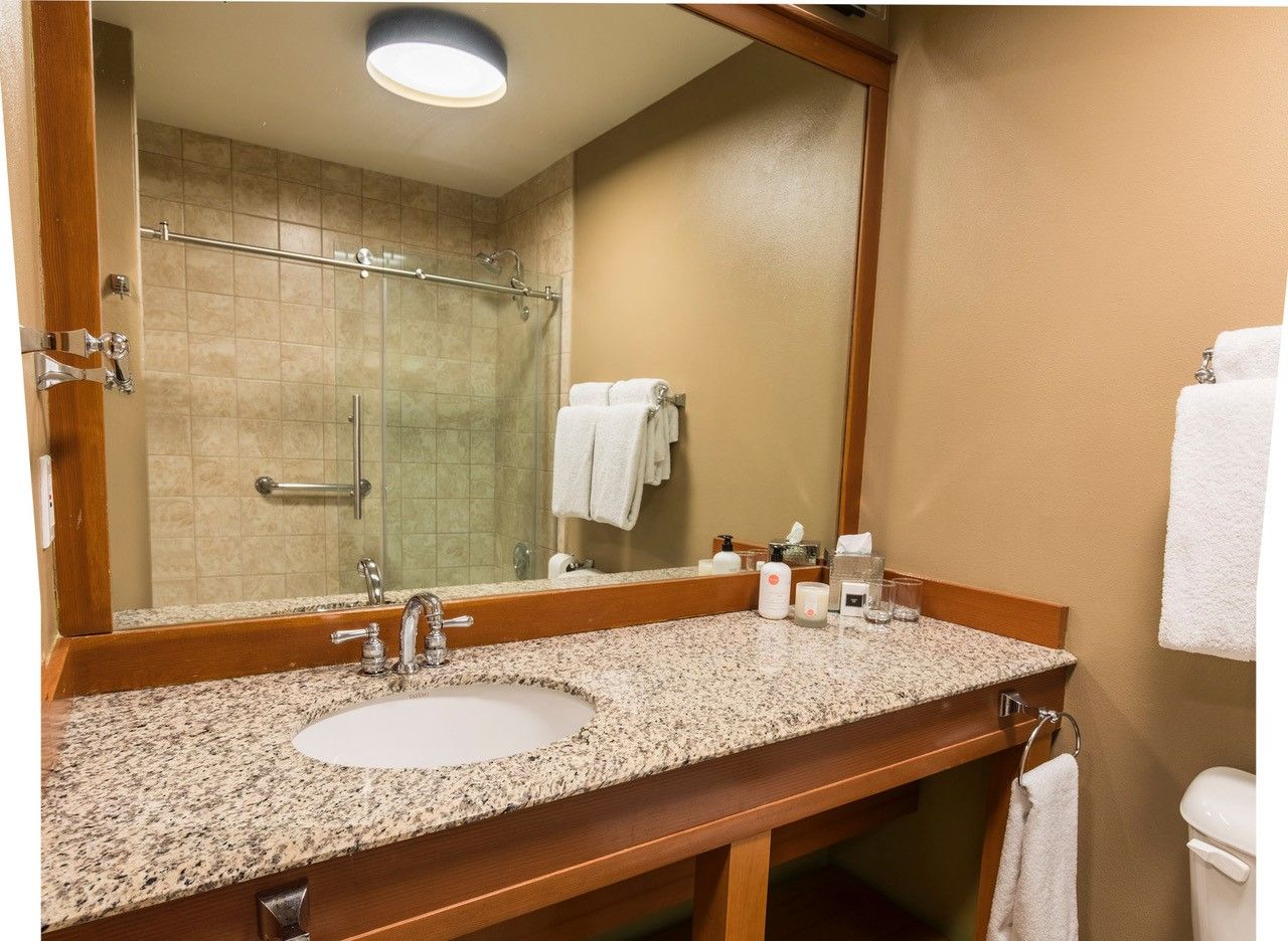 image A warm, well-lit bathroom with a sleek walk-in shower and spacious vanity, offering a calm space to refresh and unwind.