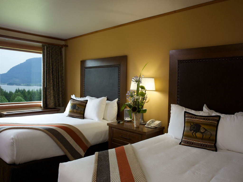 image A serene bedroom with inviting beds and a calming view, creating a restful escape.