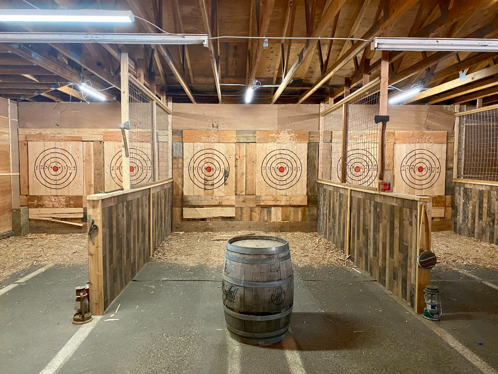 image Test your skills with an exhilarating axe-throwing session in a rustic, inviting setting.