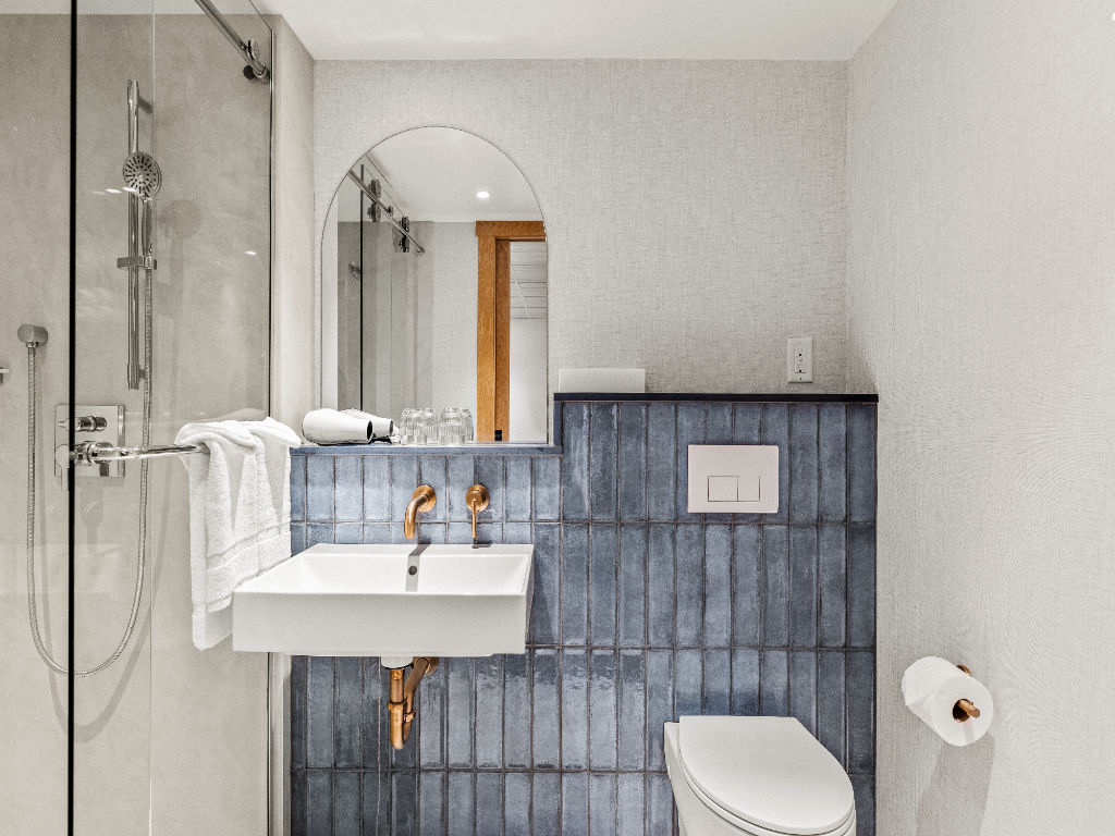 image A contemporary bathroom featuring sleek fixtures and a walk-in shower, offering a clean and calming retreat.