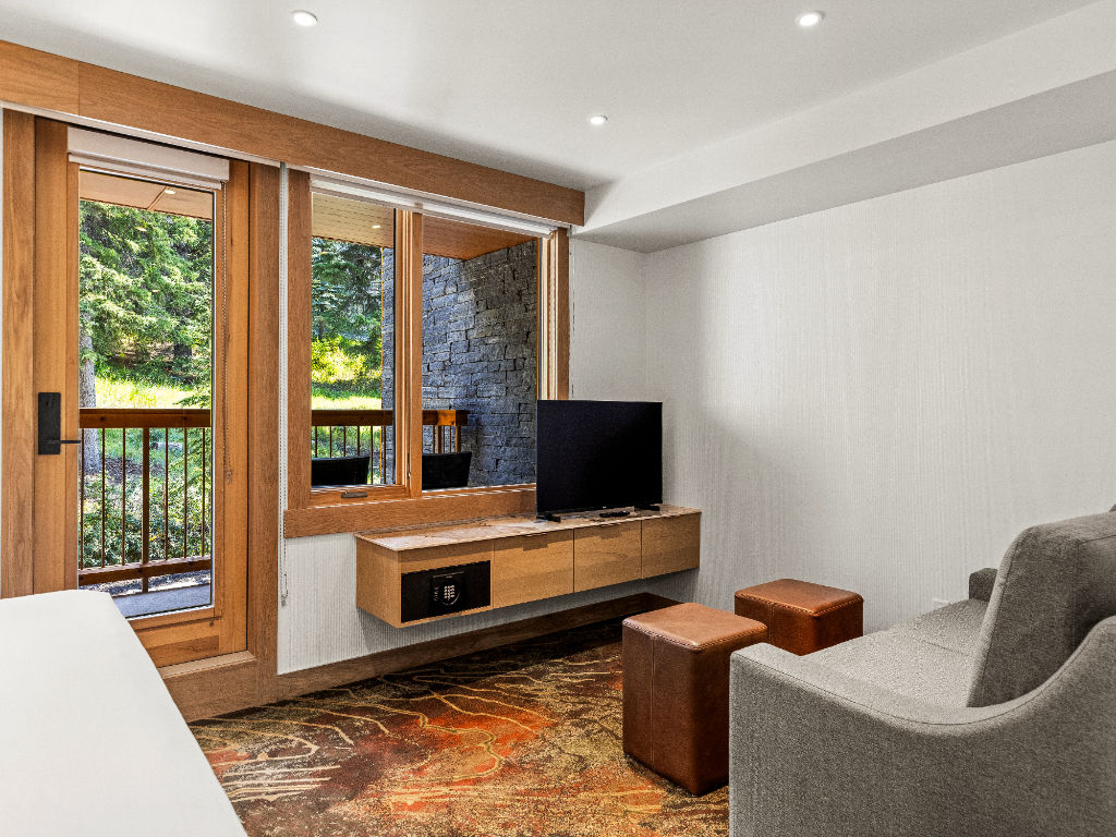 image A cozy living area with a TV and large windows, offering a relaxing space to unwind and take in the natural surroundings.