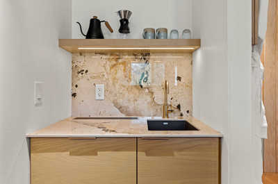 A thoughtfully designed kitchenette with natural textures and a practical layout, blending style and functionality seamlessly.
