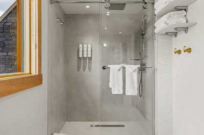 A sleek bathroom with a walk-in shower and natural light, creating a refreshing and relaxing experience.