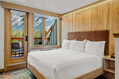 A serene bedroom with a plush bed and mountain views, designed for peaceful relaxation and restful nights.