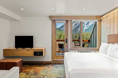 A bright and inviting bedroom with plush bedding and large windows, offering stunning views and a cozy retreat.