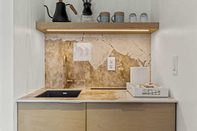 A compact and stylish kitchenette featuring modern finishes, ideal for preparing light meals in a cozy environment.