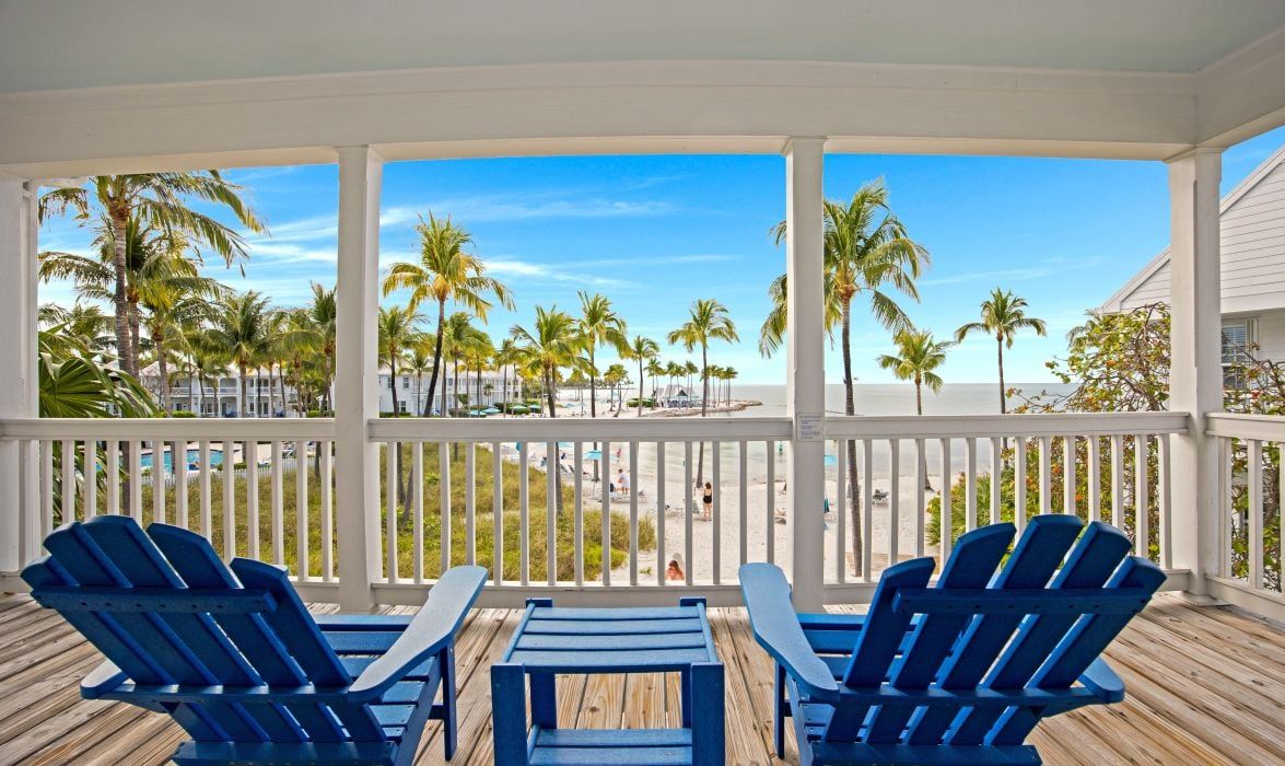 image Covered porch with blue adirondack chairs and ocean view