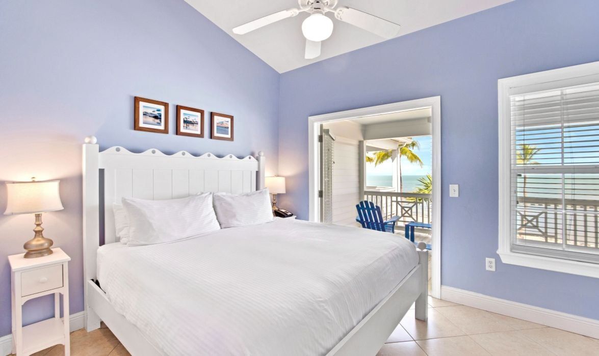 image Bedroom with white bed, soft blue walls, and ceiling fan