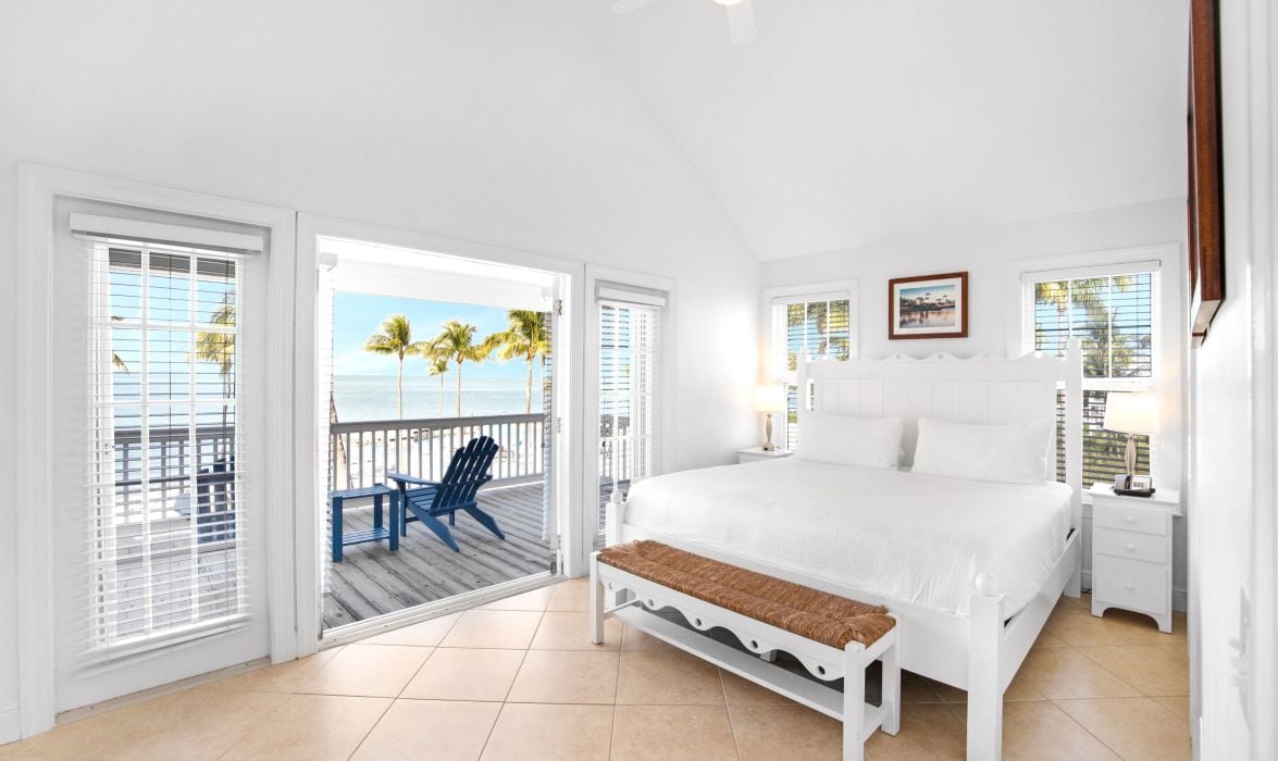 image Bedroom with white bed and French doors to a private balcony