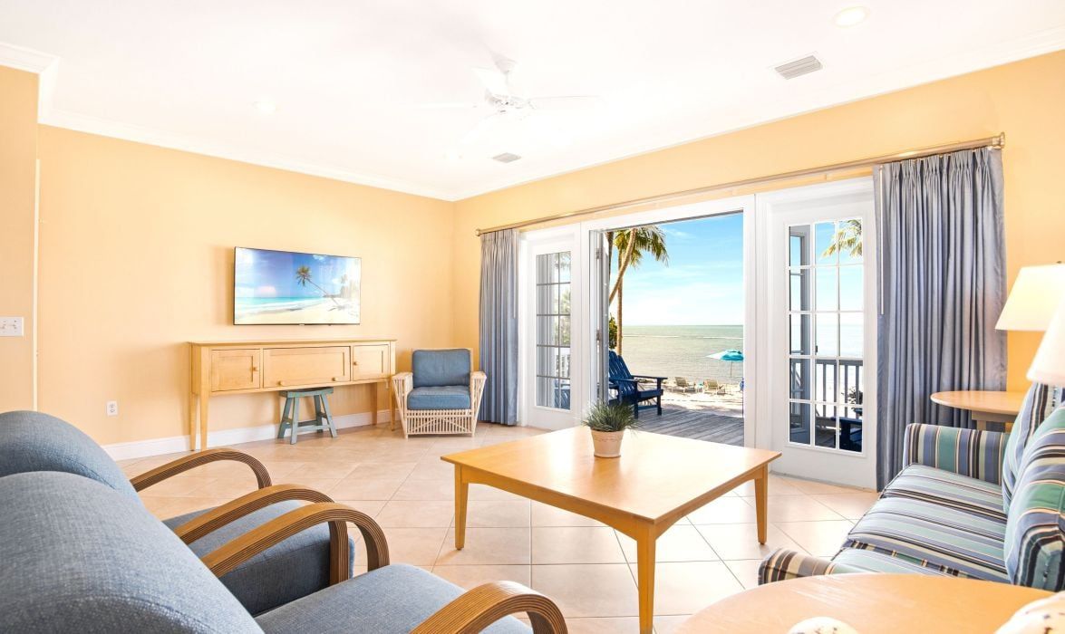 image Living room with wall-mounted TV and sliding doors to an ocean view