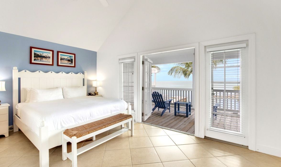 image Bedroom with white bed and French doors to a private balcony