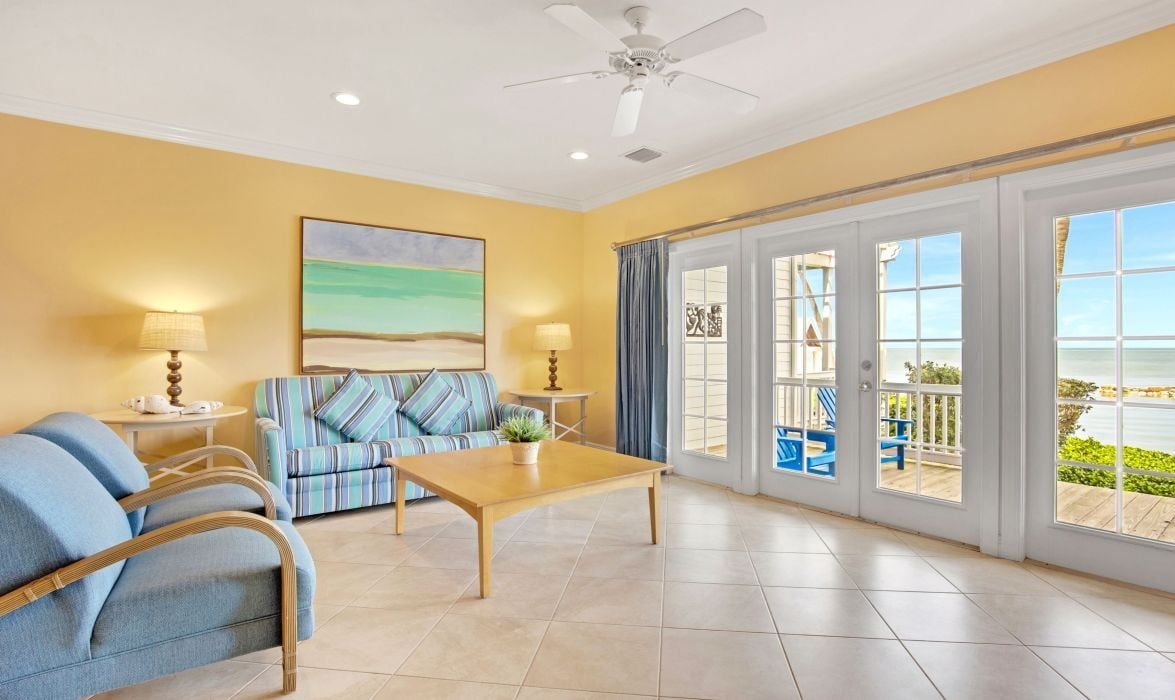 image Living room with blue sofa and French doors to a water view