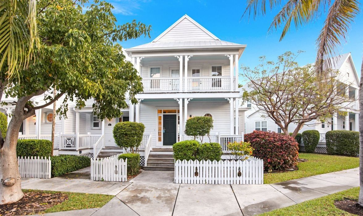 image Exterior of a two-story villa with covered porches and a picket fence