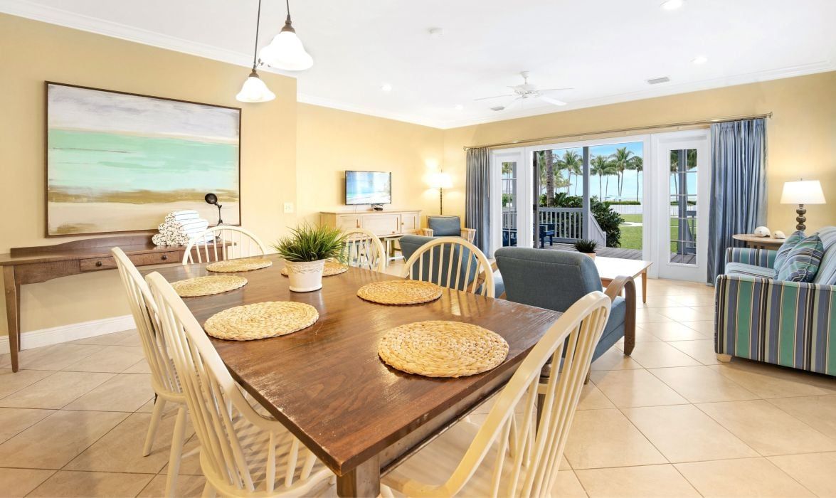 image Dining table seating six, open to a living area with water views