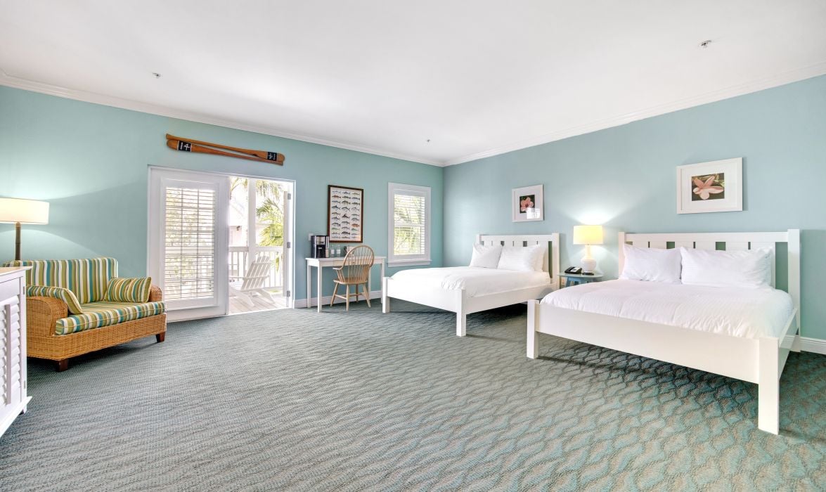 image Bedroom with queen bed, work desk, armchair, and area rug