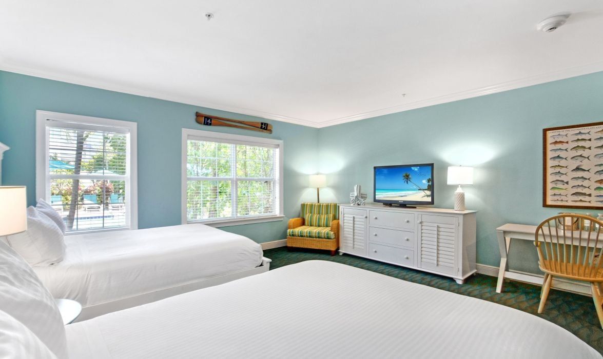 image Guest room with two queen beds, flat-screen TV, and chair