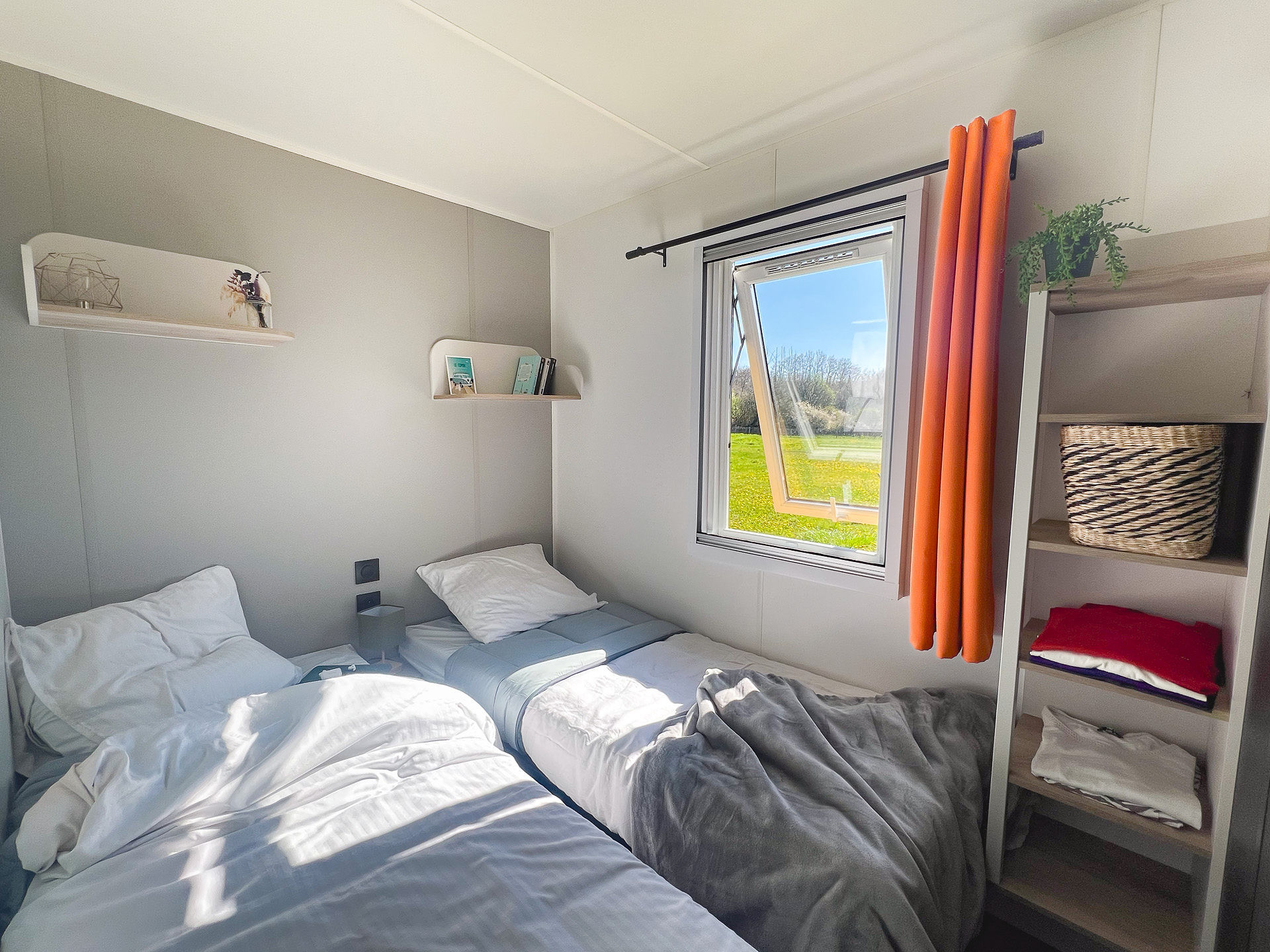 image This cozy bedroom, filled with natural light and modern decor, invites family comfort with its inviting bedding and serene views.