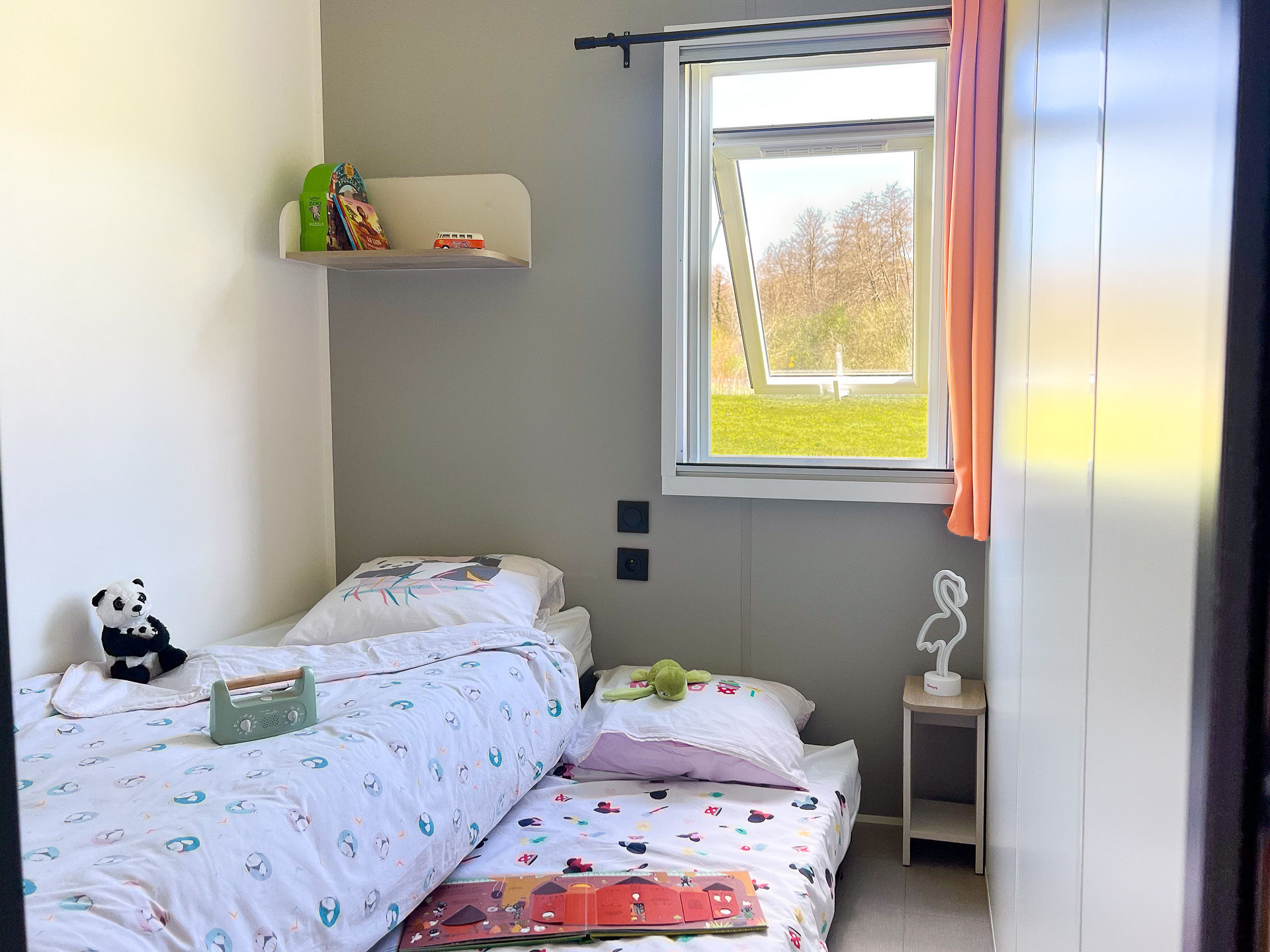 image This cozy bedroom offers a spacious retreat for children, complete with playful décor and views of lush greenery, perfect for family comfort and relaxation.
