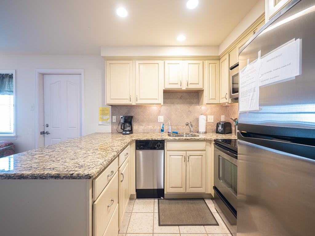 image Fully equipped modern kitchen featuring stainless steel appliances and ample counter space.