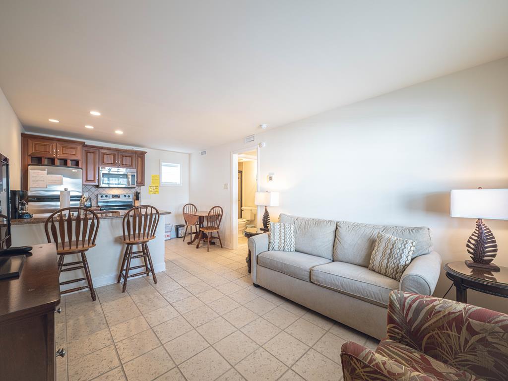 image Bright and inviting living room with a queen sleeper sofa, perfect for unwinding after a beach day.