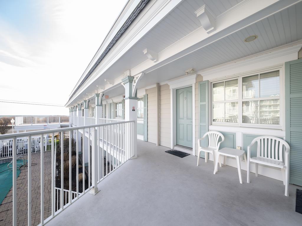 image Exterior walkway with seating, offering a peaceful spot to relax and take in the fresh ocean air.