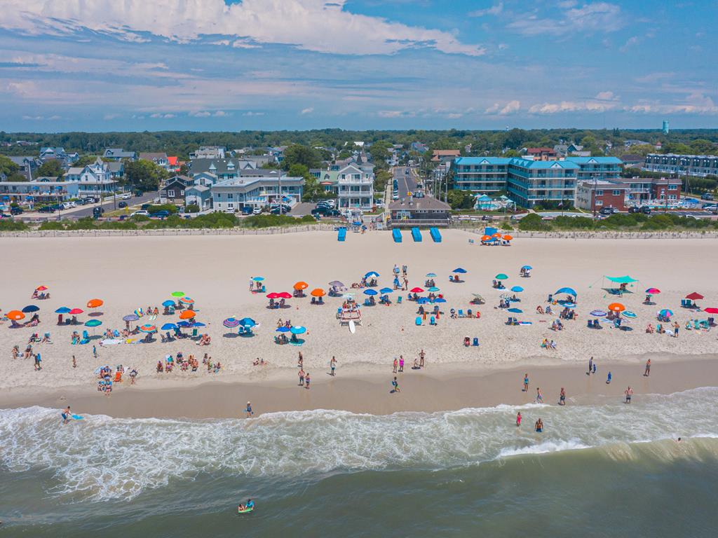 image Stunning beachfront with golden sand and vibrant beachgoers—enjoy the best of Cape May right outside your door.