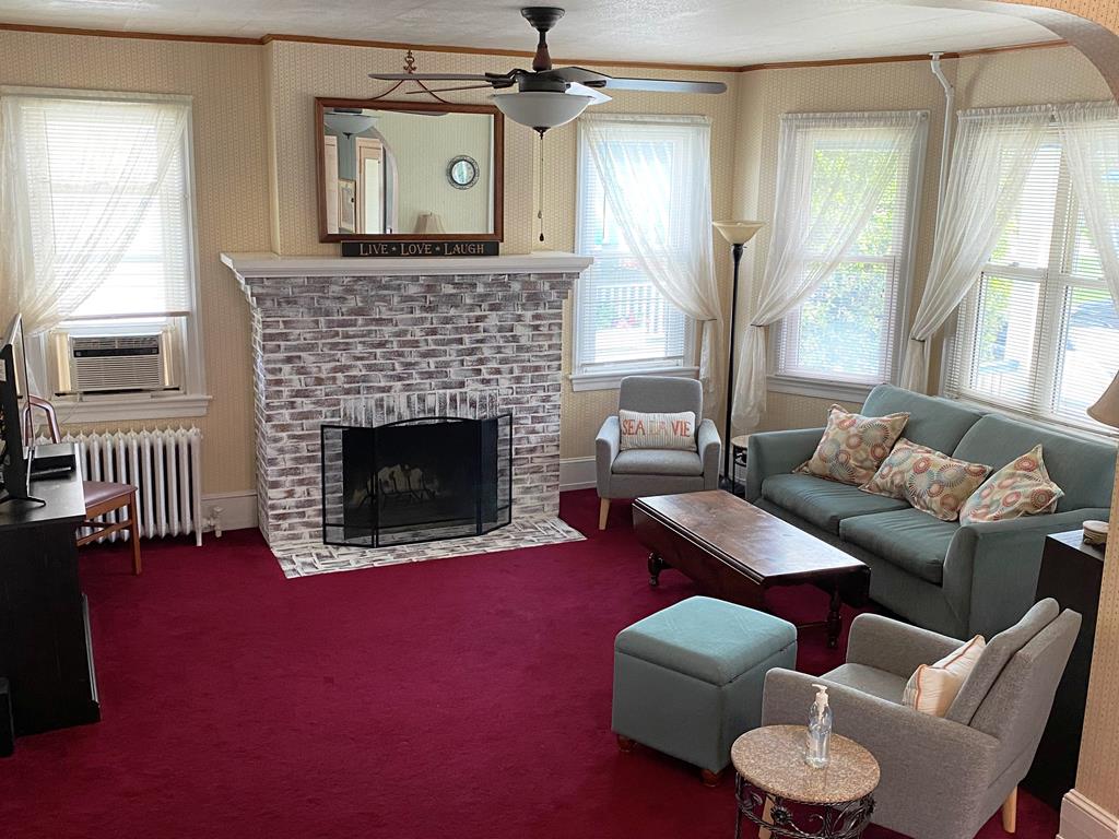 image Inviting living room with a flat-screen TV, comfortable seating, and a fireplace for cozy evenings with your group.