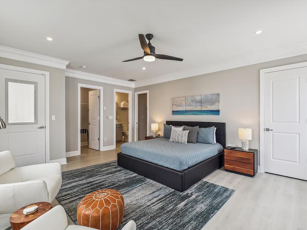 image A luxurious primary bedroom, featuring ample space and a cozy seating area.