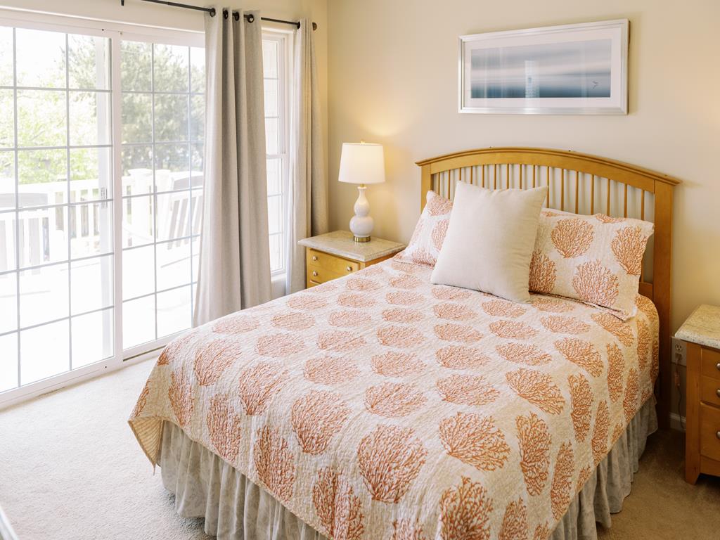 image Warm and inviting bedroom featuring a queen bed and access to one of the private decks.