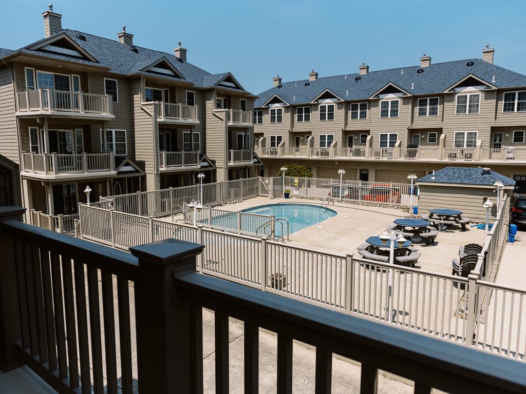 image Spacious balcony overlooking the community pool—perfect for relaxing on warm summer days.