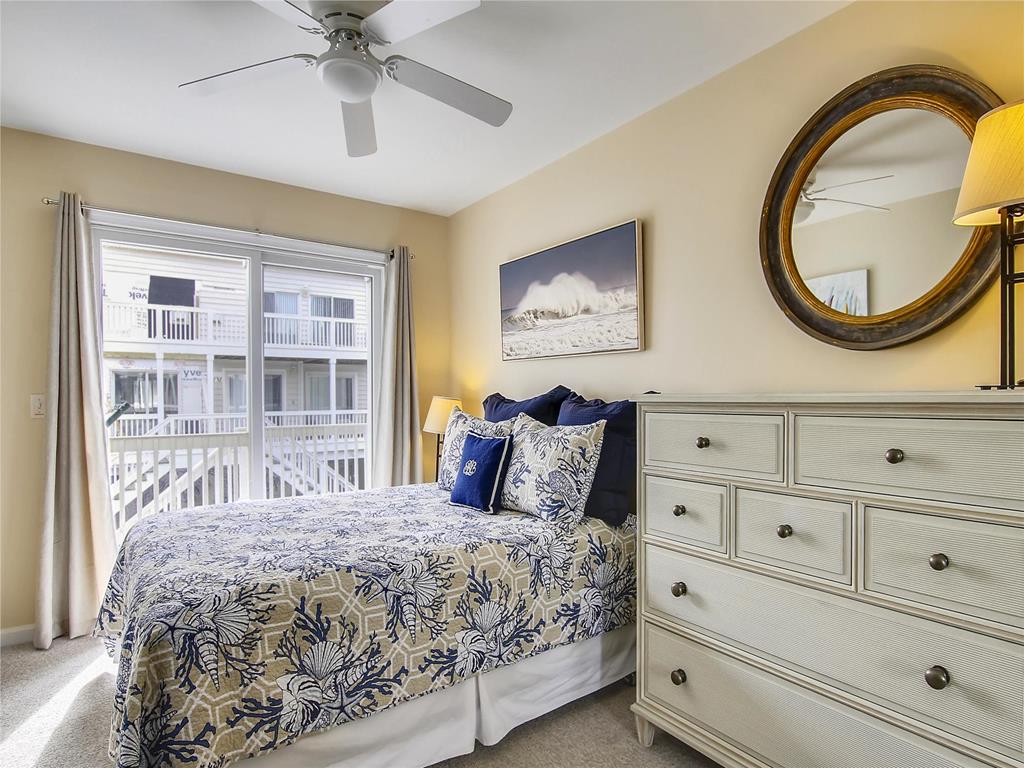 image Elegant primary suite featuring a king bed, chic décor, and plenty of natural light.