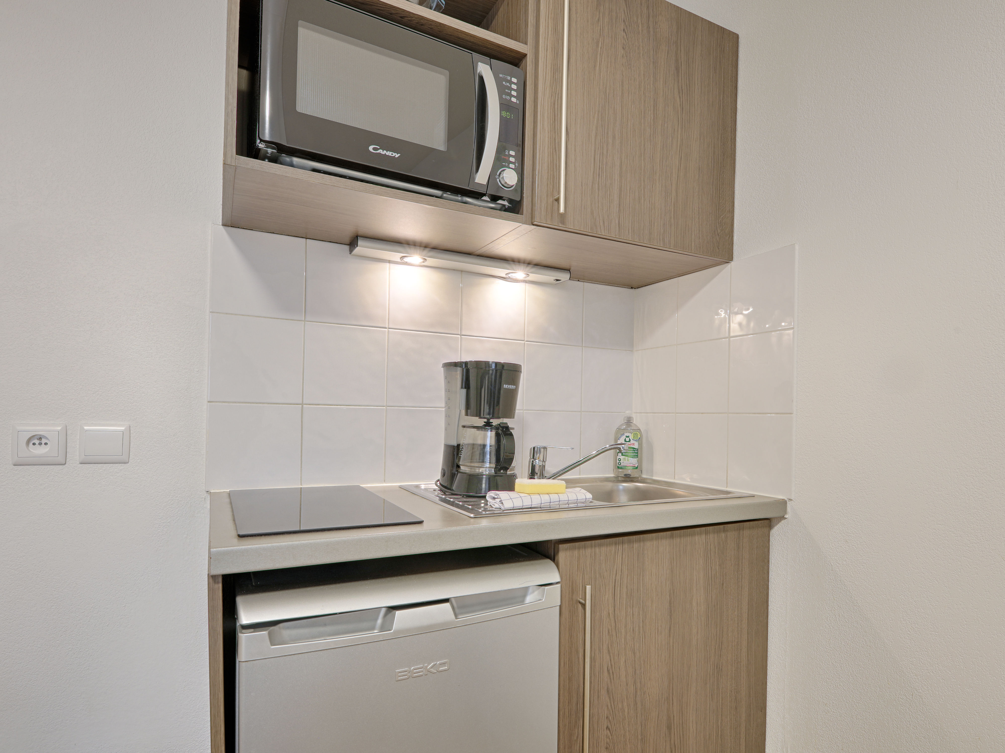 image Well-appointed kitchenette within the studio, featuring a microwave, electric hob, and compact fridge for effortless meal preparation.
