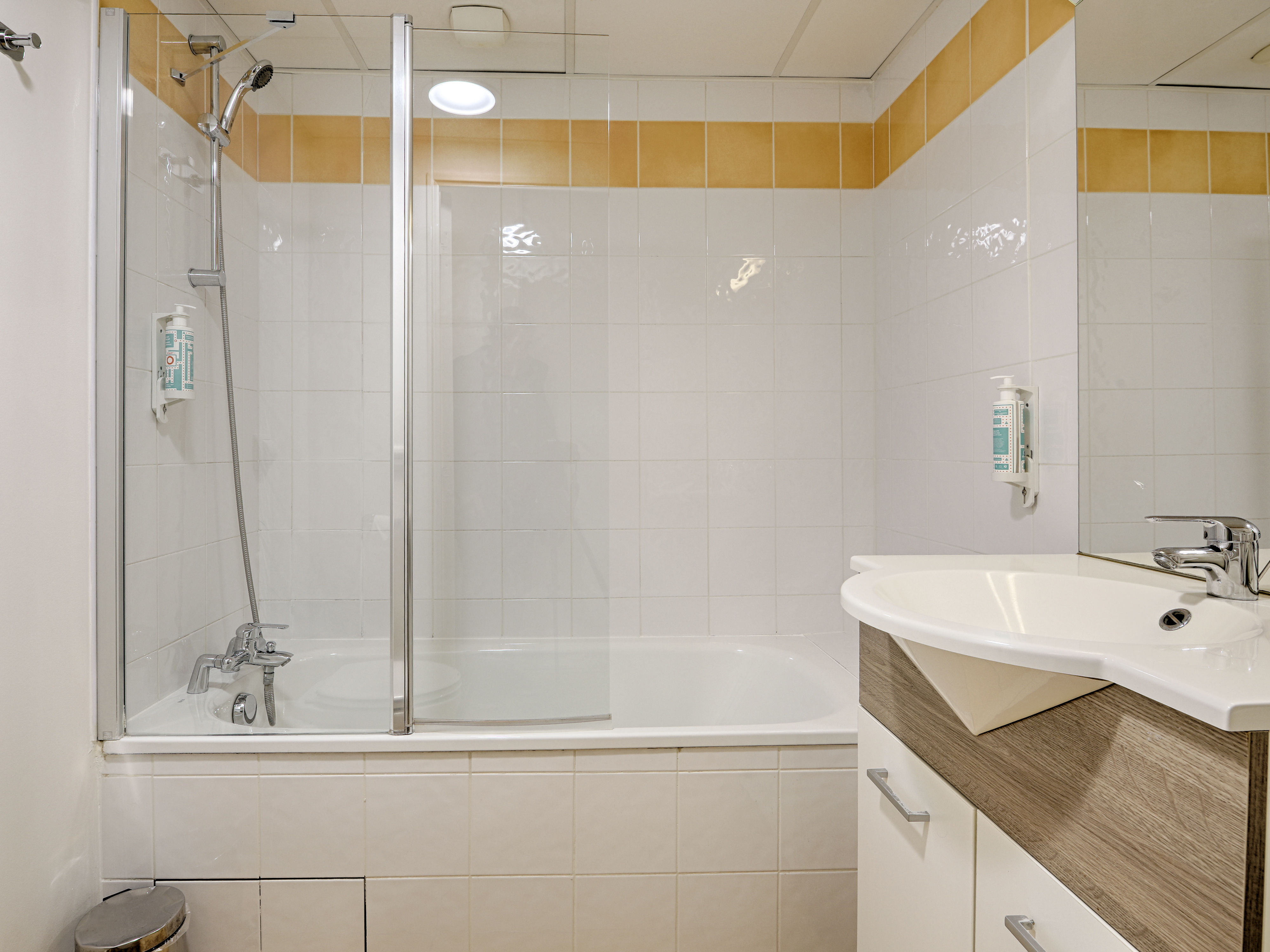 image Contemporary bathroom with a shower-tub combo and modern fixtures for a refreshing experience.