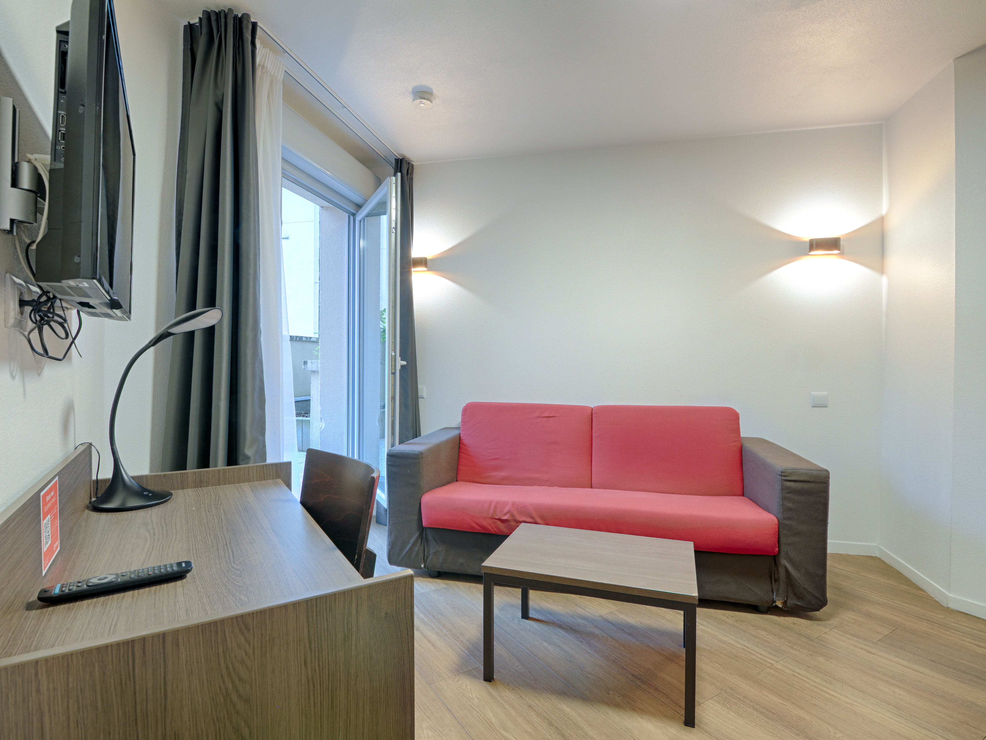 image Inviting seating area with a red sofa, perfect for relaxing after exploring nearby Paris and attractions.