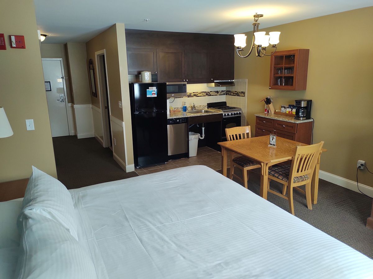 image A spacious view of the ADA-accessible studio highlights a well-equipped kitchenette and inviting dining area, ensuring both comfort and convenience for a memorable stay.