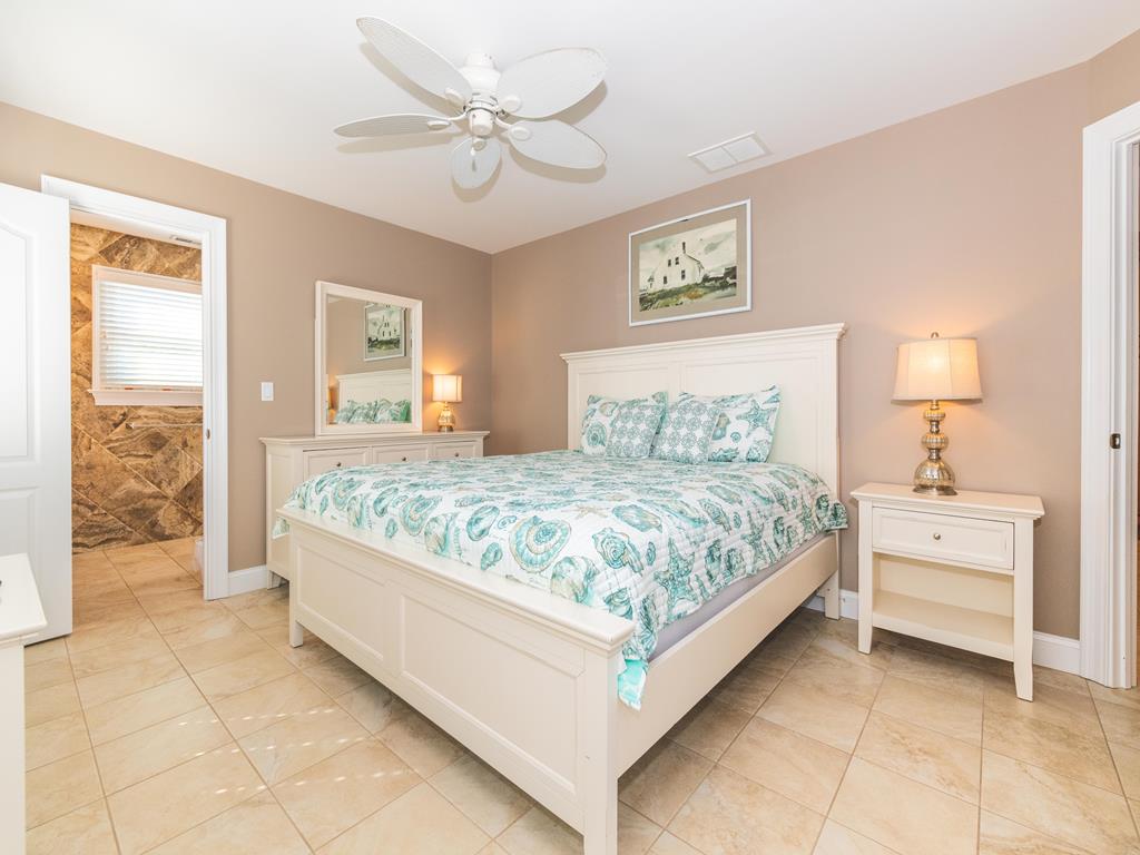 image Spacious master bedroom with natural light and cozy bedding.