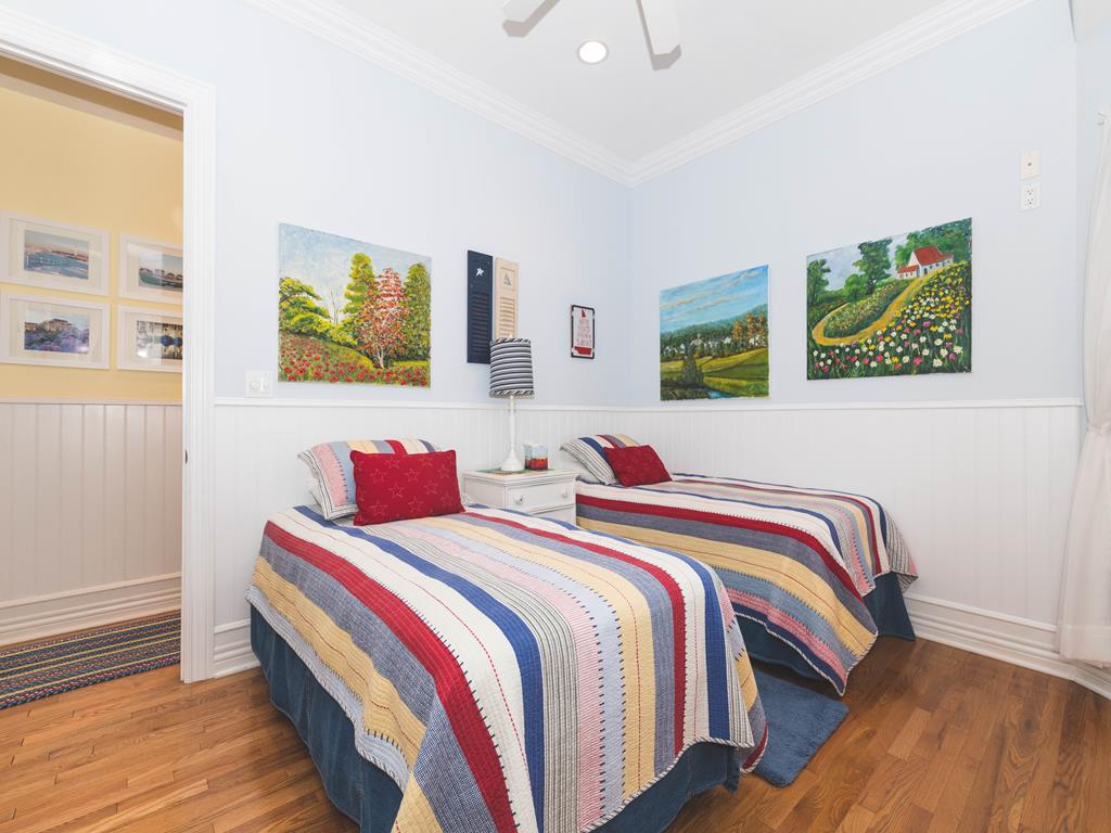 image Bright and airy bedroom with large windows and two twin beds.